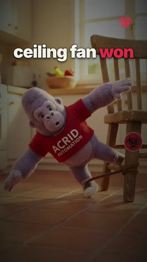 A gorilla mascot awkwardly waves at a friend and accidentally hits a ceiling fan, which wobbles and then falls to the ground, leaving both on the floor.